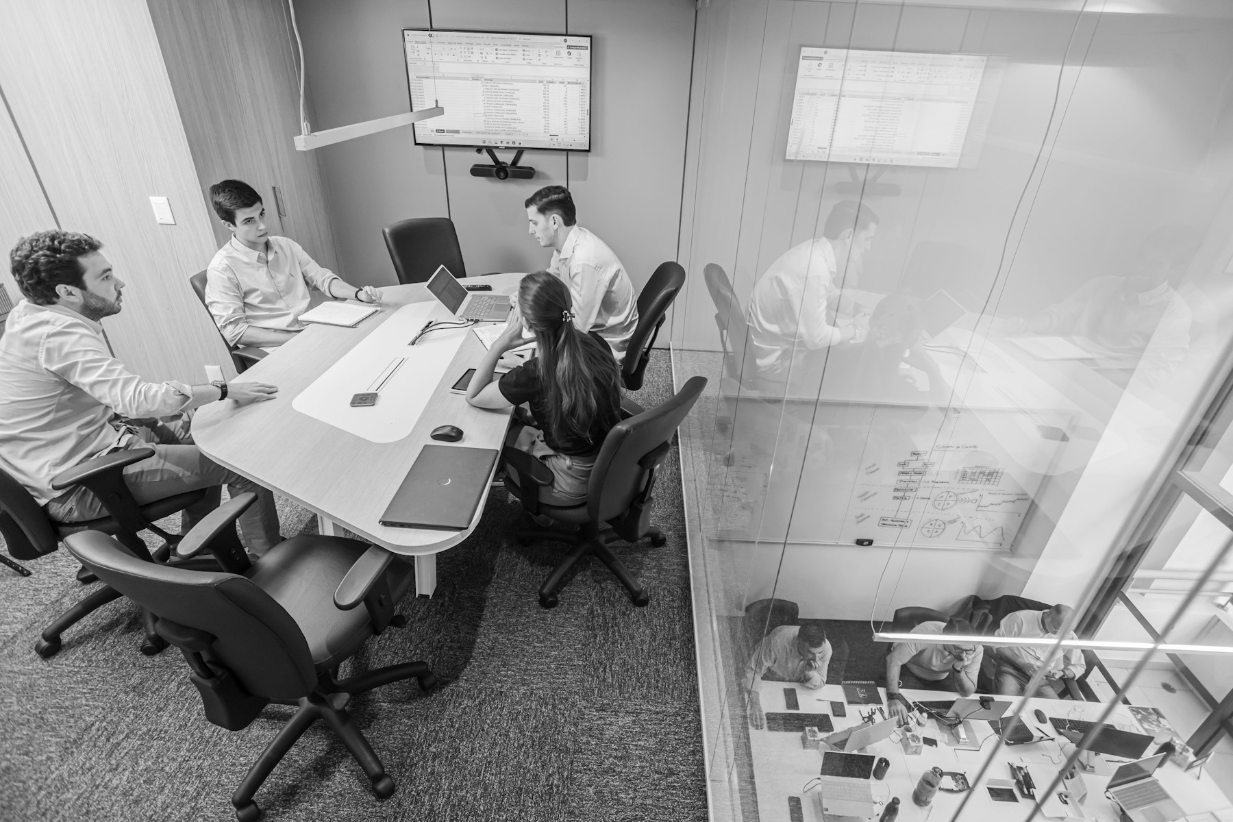 Team in a conference room planning around a screen